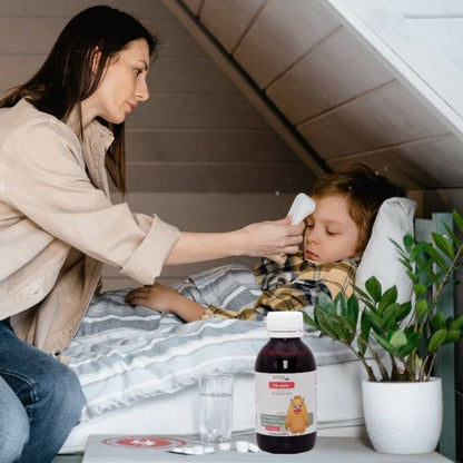 Mutter kümmert sich um krankes Kind, das im Bett liegt, im Vordergrund steht die Mirakelix Flasche auf dem Nachttisch