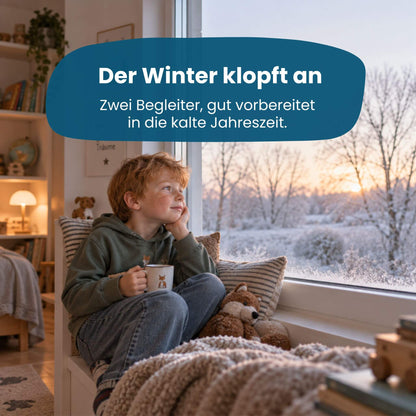 Junge sitzt gemütlich am Fenster mit Tasse und Kuscheltier, Blick auf verschneite Winterlandschaft